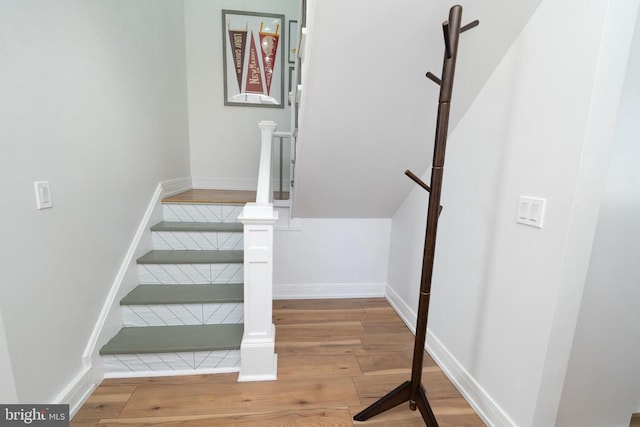 stairs featuring wood finished floors and baseboards