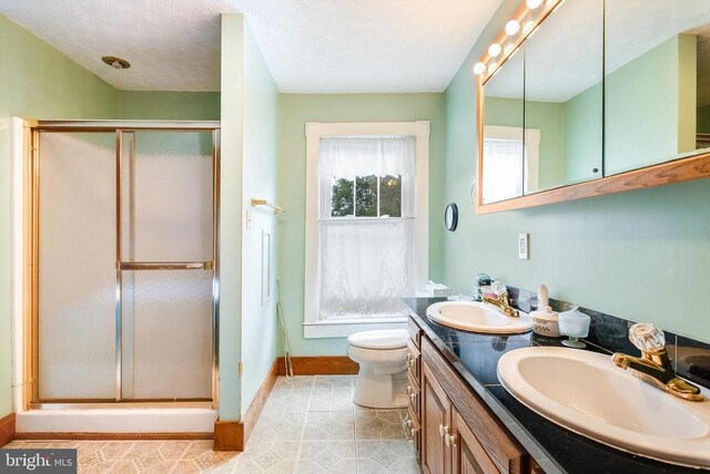 403 Long Ave, Shenandoah, VA 22849 - full bathroom featuring baseboards, a stall shower, double vanity, and toilet
