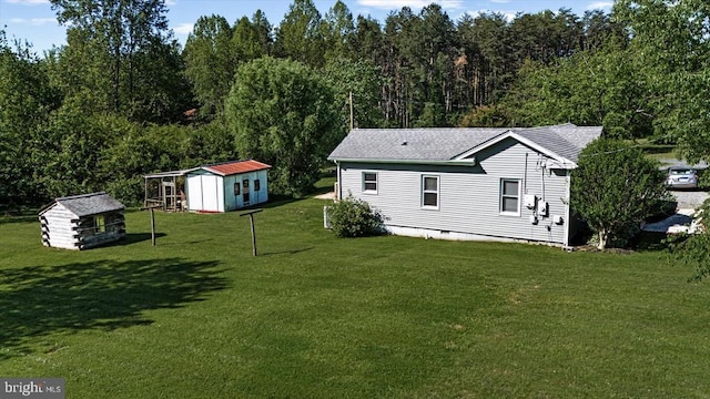 3048 Oakland Rd, Louisa, VA 23093 - view of grassy yard featuring an outdoor structure, a storage shed, and a forest view