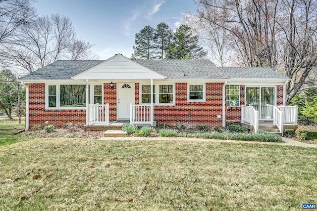view of front of house with brick siding, a front lawn, and a shingled roof