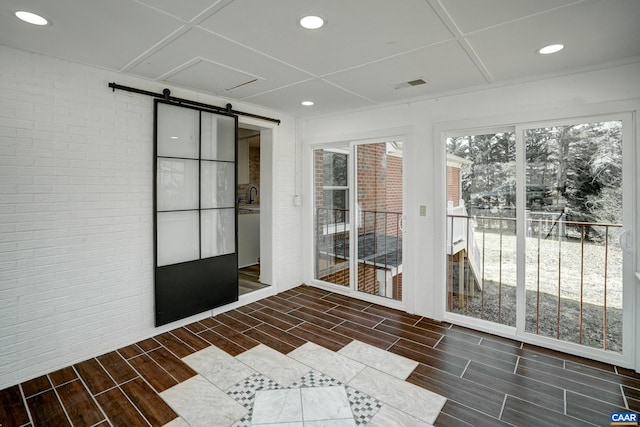 unfurnished sunroom featuring a barn door