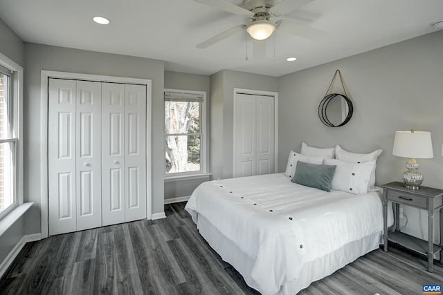 bedroom featuring multiple closets, baseboards, dark wood finished floors, recessed lighting, and a ceiling fan