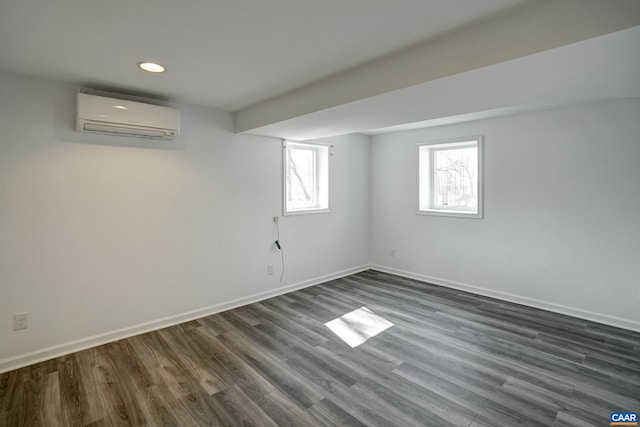below grade area featuring a wall mounted air conditioner, dark wood-style flooring, baseboards, and recessed lighting