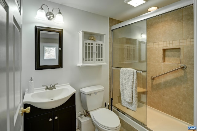 full bathroom featuring a stall shower, toilet, and vanity