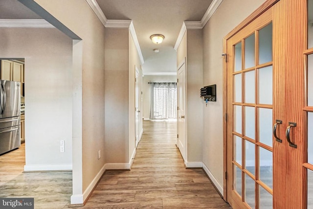 hall with ornamental molding and light hardwood / wood-style flooring