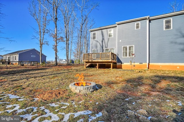 back of property with a wooden deck, crawl space, and a fire pit