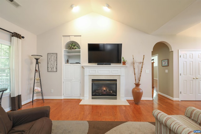 515 Broadleaf Way, Charlottesville, VA 22911 - living room featuring wood finished floors, lofted ceiling, arched walkways, and a glass covered fireplace
