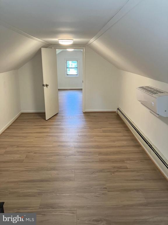 1005 Terrace St, Culpeper, VA 22701 - additional living space with wood finished floors, a wall mounted AC, and lofted ceiling