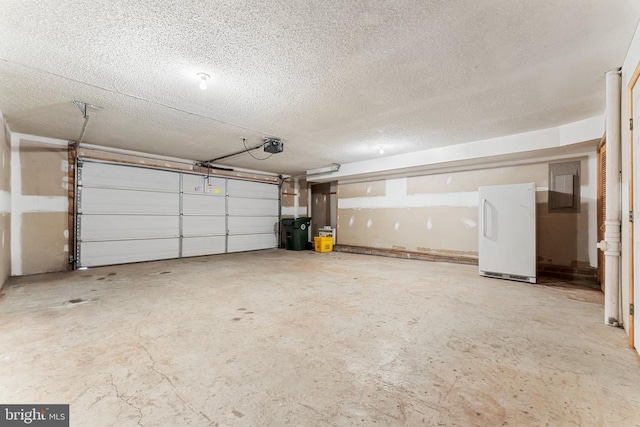 garage featuring electric panel, freestanding refrigerator, and a garage door opener