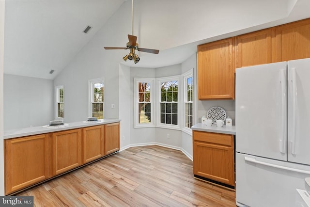 kitchen featuring visible vents, baseboards, light wood-style floors, light countertops, and freestanding refrigerator