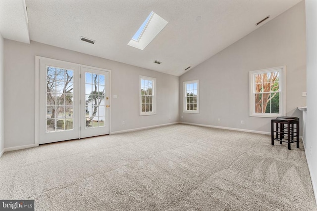 interior space with a skylight, carpet flooring, visible vents, and a textured ceiling