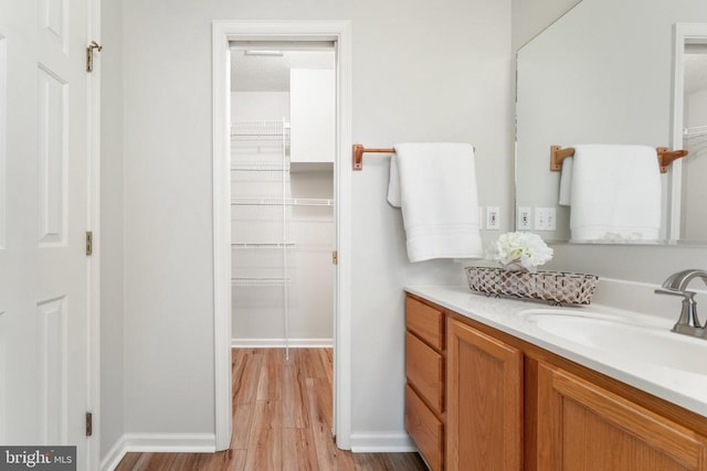 bathroom featuring a textured ceiling, wood finished floors, vanity, and baseboards