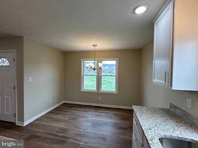 218 Honeyville Rd, Stanley, VA 22851 - unfurnished dining area with a chandelier, dark wood-style flooring, baseboards, and a textured ceiling