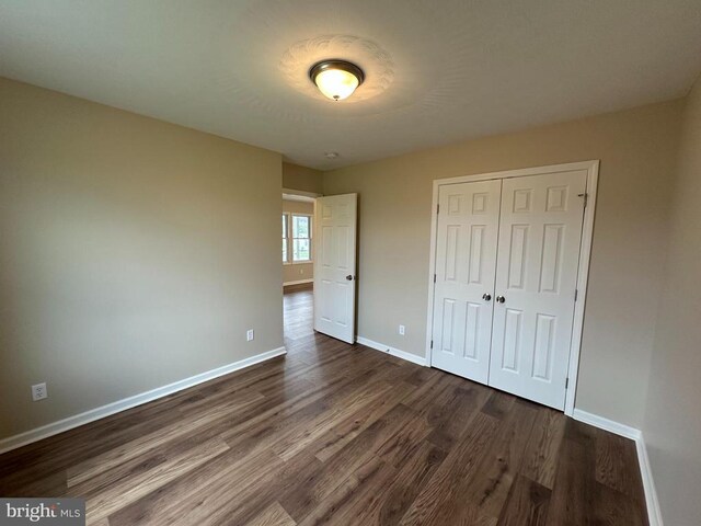 218 Honeyville Rd, Stanley, VA 22851 - unfurnished bedroom with dark wood-type flooring, baseboards, and a closet