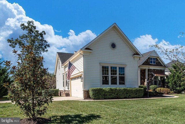 11407 Osprey Trl, Spotsylvania, VA 22551 - view of front facade with stone siding, a front yard, driveway, and a garage
