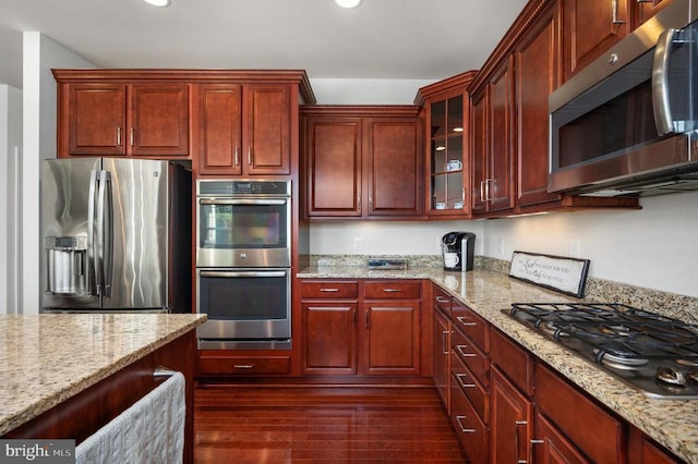 11407 Osprey Trl, Spotsylvania, VA 22551 - kitchen featuring light stone countertops, stainless steel appliances, dark wood-style flooring, and dark brown cabinets