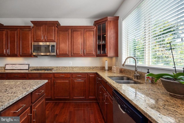 11407 Osprey Trl, Spotsylvania, VA 22551 - kitchen featuring glass insert cabinets, light stone counters, a sink, appliances with stainless steel finishes, and dark wood-style floors
