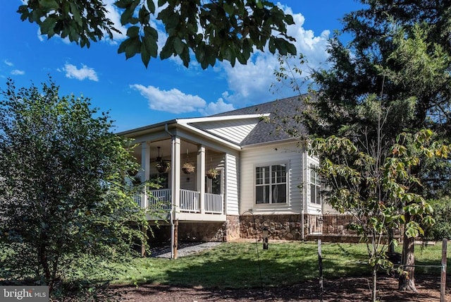 11407 Osprey Trl, Spotsylvania, VA 22551 - view of side of property with a yard, ceiling fan, stone siding, a porch, and roof with shingles