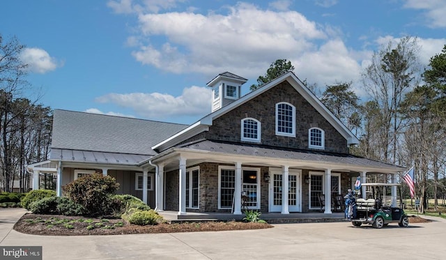 11407 Osprey Trl, Spotsylvania, VA 22551 - exterior space featuring covered porch, stone siding, metal roof, board and batten siding, and a standing seam roof