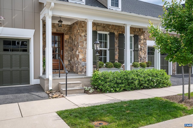 312 Avondale Ln, Crozet, VA 22932 - property entrance featuring stone siding, roof with shingles, covered porch, and a garage