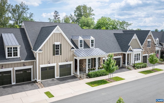 312 Avondale Ln, Crozet, VA 22932 - view of front of home featuring a standing seam roof, board and batten siding, roof with shingles, driveway, and stone siding