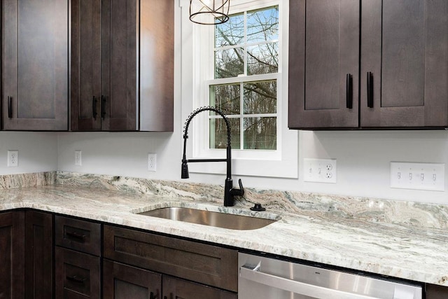 kitchen featuring sink, dark brown cabinets, stainless steel dishwasher, and light stone countertops