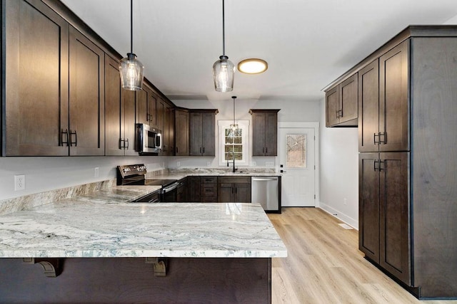 kitchen with dark brown cabinetry, sink, hanging light fixtures, appliances with stainless steel finishes, and kitchen peninsula