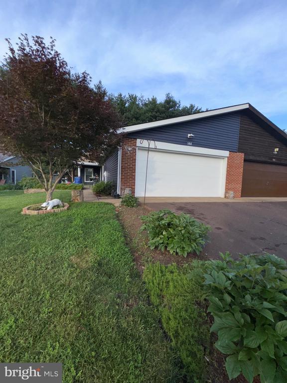588 Meadowbrook Dr, Culpeper, VA 22701 - view of home's exterior featuring brick siding, a yard, driveway, and a garage
