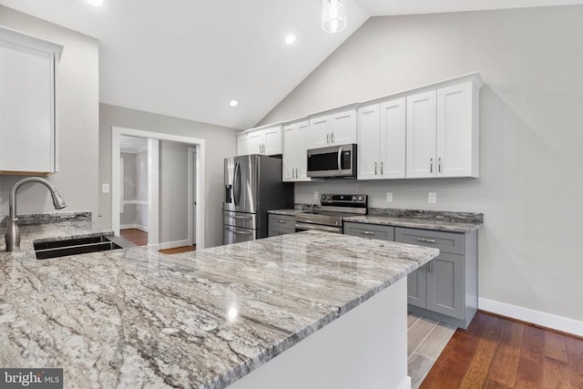 9712 Sutter Rd, Partlow, VA 22534 - kitchen with appliances with stainless steel finishes, a sink, light stone countertops, vaulted ceiling, and a peninsula