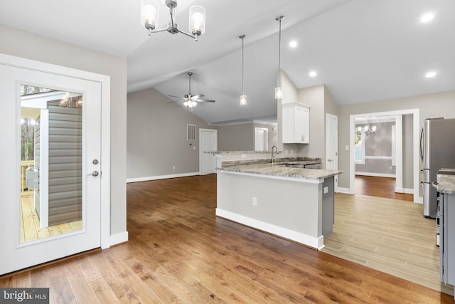 9712 Sutter Rd, Partlow, VA 22534 - kitchen featuring a chandelier, lofted ceiling, freestanding refrigerator, a sink, and a peninsula