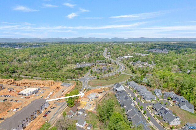 aerial view of property and surrounding area featuring mountains and a forest