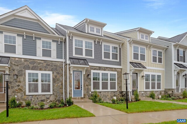 view of property with a front lawn and stone siding