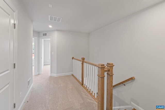 corridor featuring baseboards, an upstairs landing, and visible vents