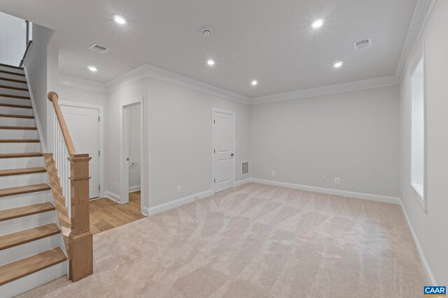 basement featuring stairs, crown molding, visible vents, and light colored carpet