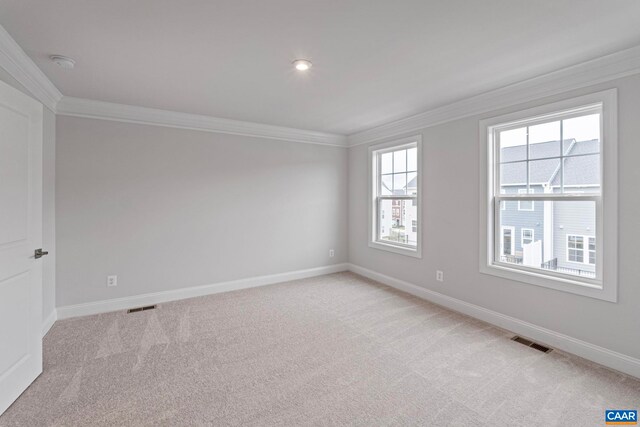 empty room with light carpet, crown molding, and visible vents
