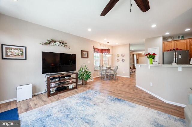  - living room featuring light wood finished floors, ceiling fan, baseboards, and recessed lighting