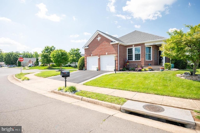  - view of front of home with brick siding, driveway, a front yard, and an attached garage