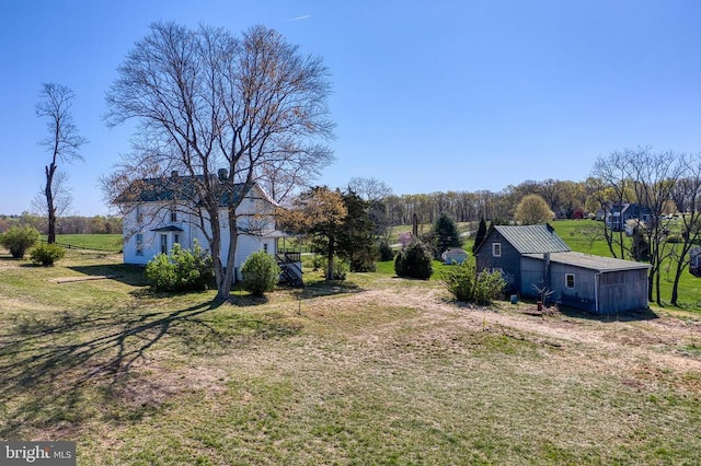 view of green lawn featuring an outbuilding