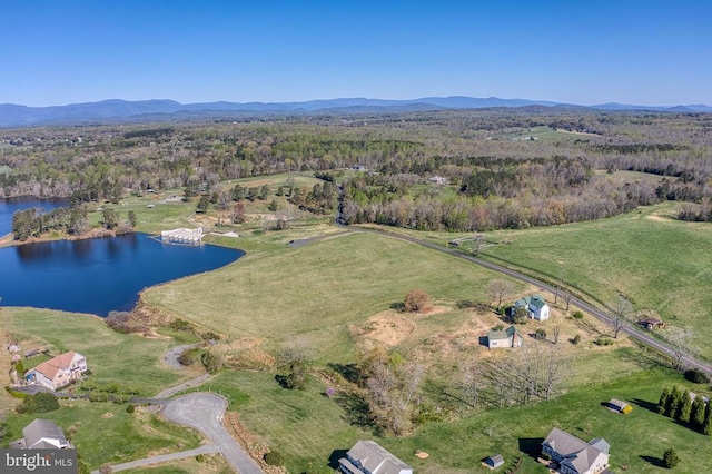 aerial view of property's location featuring a water and mountain view and a heavily wooded area