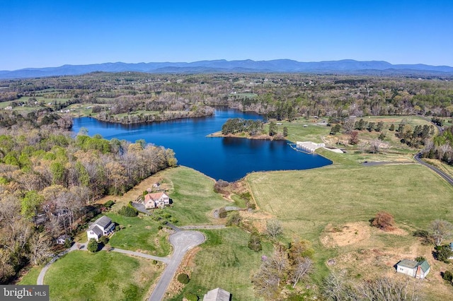 aerial view of property's location with a water and mountain view and a heavily wooded area