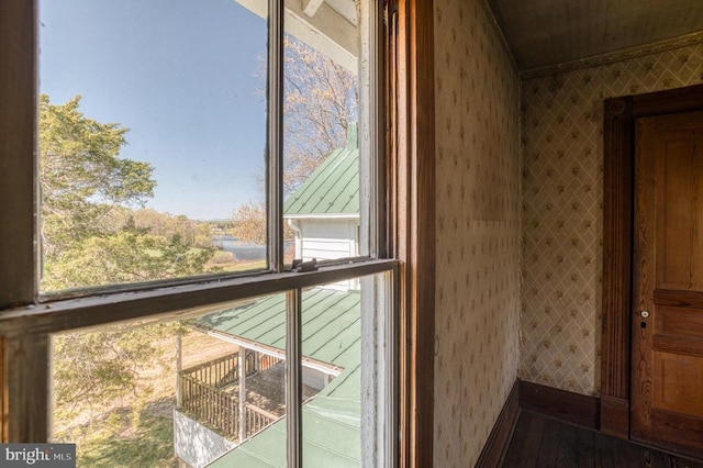 detailed view of wallpapered walls, crown molding, and wood finished floors