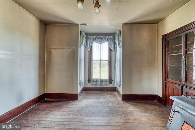 empty room featuring wood-type flooring and baseboards