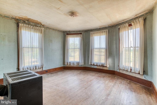 spare room featuring hardwood / wood-style floors and baseboards