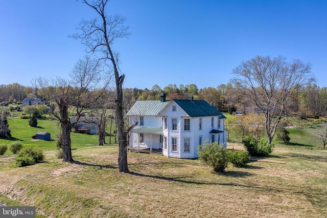 view of front of property featuring a front lawn and metal roof
