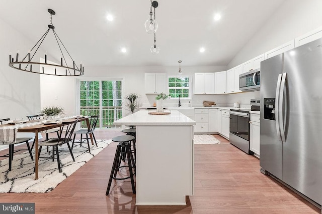 13191 Scotts Ml, Culpeper, VA 22701 - kitchen featuring appliances with stainless steel finishes, vaulted ceiling, a center island, light countertops, and a kitchen bar