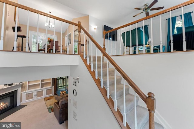 10603 Eden Brook Dr, Spotsylvania, VA 22553 - stairs with a ceiling fan, a chandelier, a fireplace with flush hearth, plenty of natural light, and a high ceiling