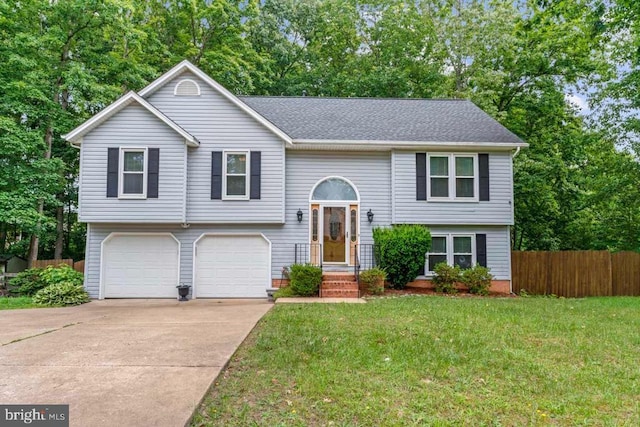 10603 Eden Brook Dr, Spotsylvania, VA 22553 - split foyer home featuring an attached garage, driveway, view of scattered trees, and roof with shingles