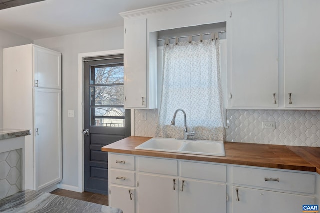 kitchen featuring wood counters, tasteful backsplash, and a sink