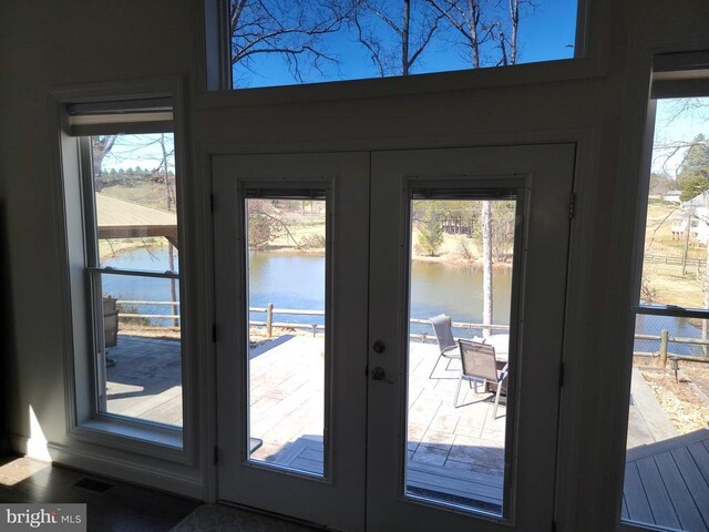  - doorway featuring french doors, a water view, and plenty of natural light