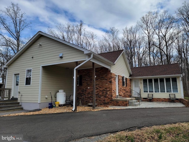  - view of property exterior with brick siding and roof with shingles